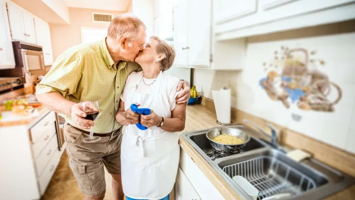 elderly couple kissing each otehr