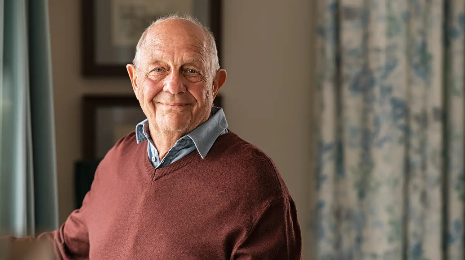 happy senior man looking at camera at home
