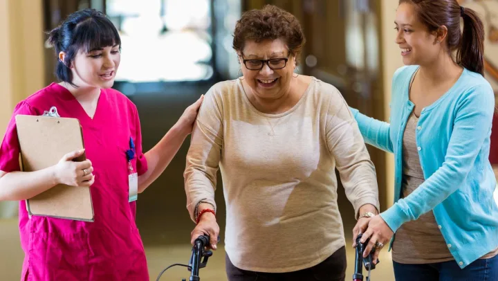 nurse and young woman assisting elderly woman